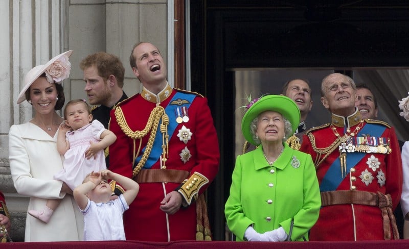 A rainha Elizabeth II em um vestido verde-limão saúda os súditos no Palácio de Buckingham