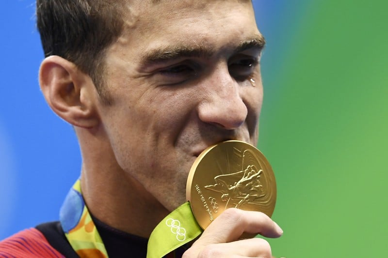 USA's Michael Phelps kisses his gold medal on the podium of the Men's 4x100m Freestyle Relay Final during the swimming event at the Rio 2016 Olympic Games at the Olympic Aquatics Stadium in Rio de Janeiro on August 7, 2016. 