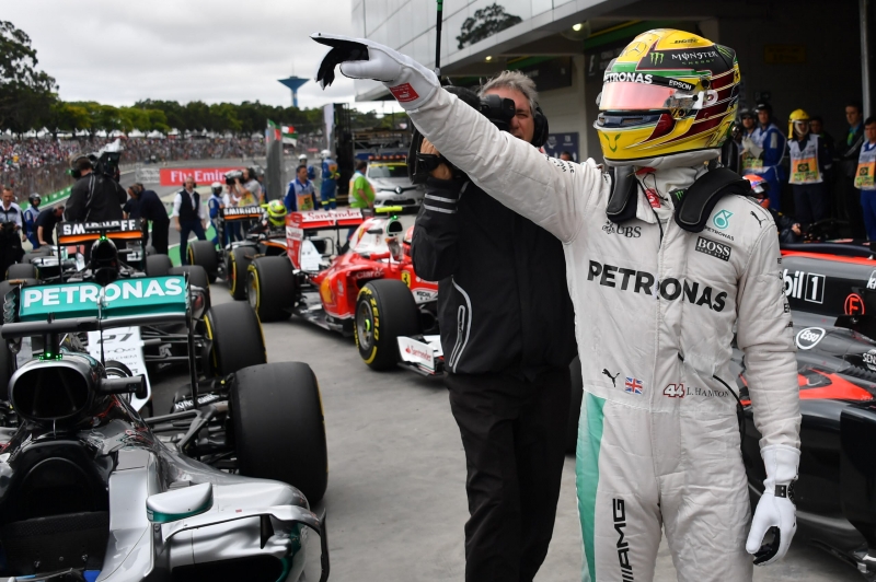 Mercedes AMG Petronas F1 Team's British driver Lewis Hamilton celebrates after obtaining the pole position in the qualifying session of the Formula One Brazilian Grand Prix, in Sao Paulo, Brazil, on November 12, 2016.  / AFP PHOTO / Nelson Almeida
      Caption