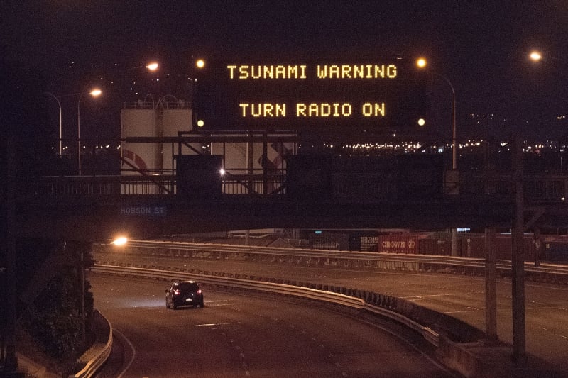 A tsunami warning alert is seen on a notice board above State Highway 1 in Wellington early on November 14, 2016 following an earthquake centred some 90 kilometres (57 miles) north of New Zealand's South Island city of Christchurch. 
A powerful 7.8 magnitude earthquake rocked New Zealand early November 14, the US Geological Survey said, prompting a tsunami warning and knocking out power and phone services in many parts of the country.  / AFP PHOTO / Marty Melville
      Caption