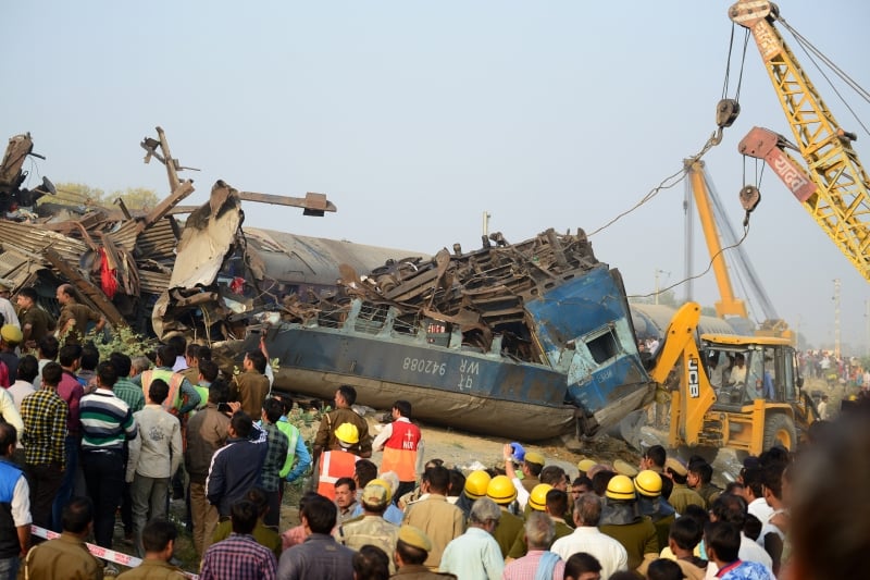 Indian rescue workers search for survivors in the wreckage of a train that derailed near Pukhrayan in Kanpur district on November 20, 2016.
A passenger train derailed in northern India on November 20, killing at least 63 travellers most of whom were sleeping when the fatal accident occurred, police said. Rescue workers rushed to the scene near Kanpur in Uttar Pradesh state where the Patna-Indore express train derailed in the early hours of the morning. / AFP PHOTO / SANJAY KANOJIA
      Caption