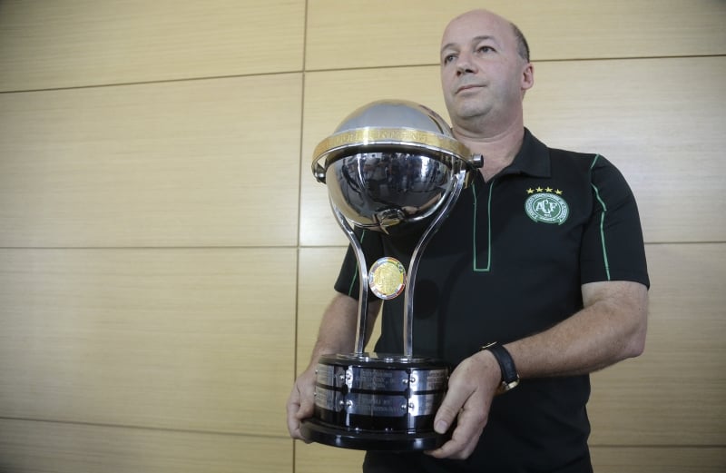 The director of Brazil's Chapecoense football club, Marcelo Zolet, holds a replica of a Copa Sudamericana trophy, sent by the president of Colombia's Independiente Santa Fe, Cesar Pastrana (not in frame) as a tribute, at Olaya Herrera airport in Medellin, Colombia on December 1, 2016. / AFP PHOTO / STR / RAUL ARBOLEDA