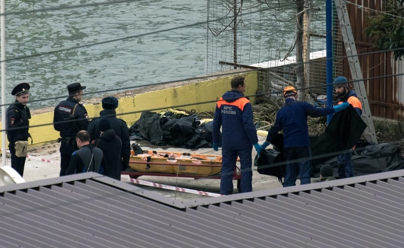 Russian policemen and rescuers stand near a stretcher with a body recovered after a Russian military plane crashed in the Black Sea, on a pier outside Sochi, on December 25, 2016.
The Russian military plane crashed on its way to Syria on December 25, with no sign of survivors among the 92 onboard, who included dozens of Red Army Choir members heading to celebrate the New Year with troops. Russia's defence ministry said a body had been recovered from the Black Sea. / AFP PHOTO / Ekaterina LYZLOVA