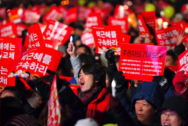 Protesters attend a candle-lit rally calling for South Korean President Park Geun-Hye's immediate departure from her office, in downtown Seoul on December 31, 2016.
South Korea sees in the new year with a massive protest calling for an immediate arrest of impeached President Park Geun-Hye. / AFP PHOTO / JUNG Yeon-Je