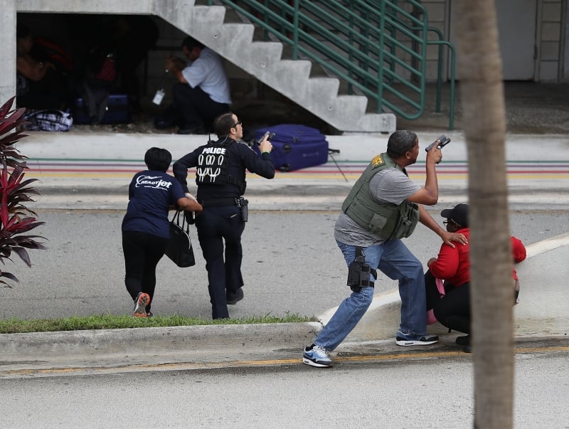 FORT LAUDERDALE, FL - JANUARY 06: Police assist people seeking cover outside of Terminal 2 at Fort Lauderdale-Hollywood International airport after a shooting took place near the baggage claim on January 6, 2017 in Fort Lauderdale, Florida. Officials are reporting that five people wear killed and eight wounded in an attack from a single gunman.   Joe Raedle/Getty Images/AFP