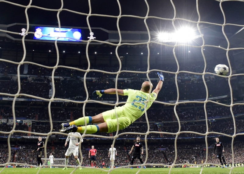 Napoli's goalkeeper from Spain Pepe Reina (C) dives for the ball as Real Madrid's Brazilian midfielder Casemiro scores a goal during the UEFA Champions League round of 16 first leg football match Real Madrid CF vs SSC Napoli at the Santiago Bernabeu stadium in Madrid on February 15, 2017. 
