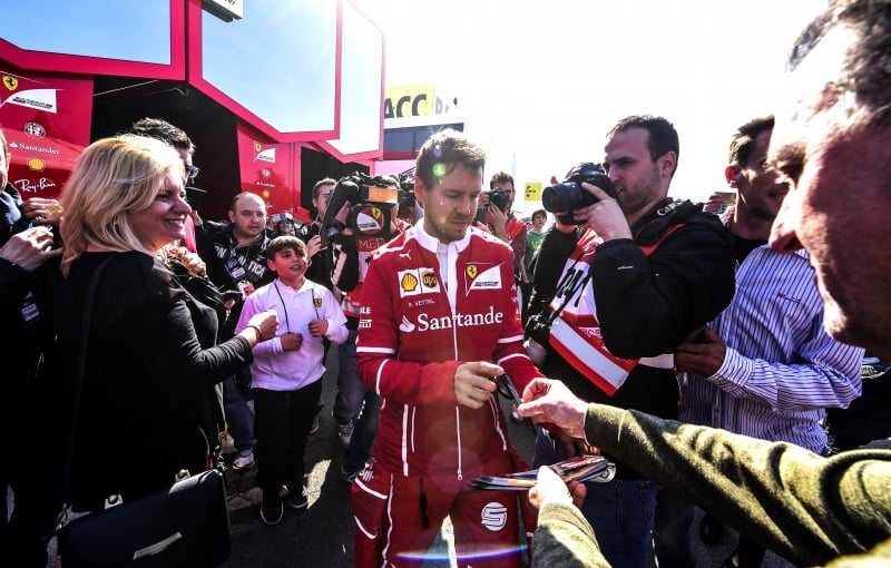 Ferrari's German driver Sebastian Vettel signs autographs at the Circuit de Catalunya on February 27, 2017 in Montmelo on the outskirts of Barcelona during the first day of the first week of tests for the Formula One Grand Prix season.  / AFP PHOTO / JOSE JORDAN