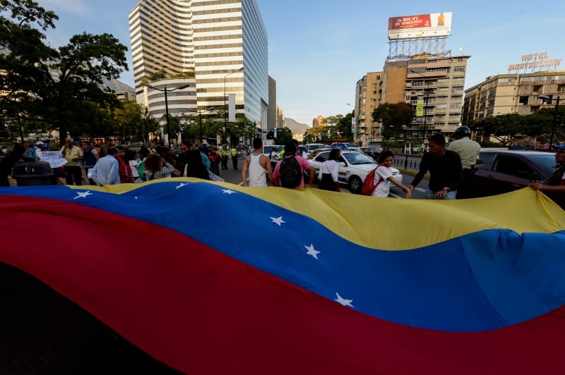 Venezuelan opposition activists, display a national flag during a march against President Nicolas Maduro's government, on March 31, 2017.
Venezuela's Supreme Court took over legislative powers Thursday from the opposition-majority National Assembly, whose speaker accused leftist President Nicolas Maduro of staging a 