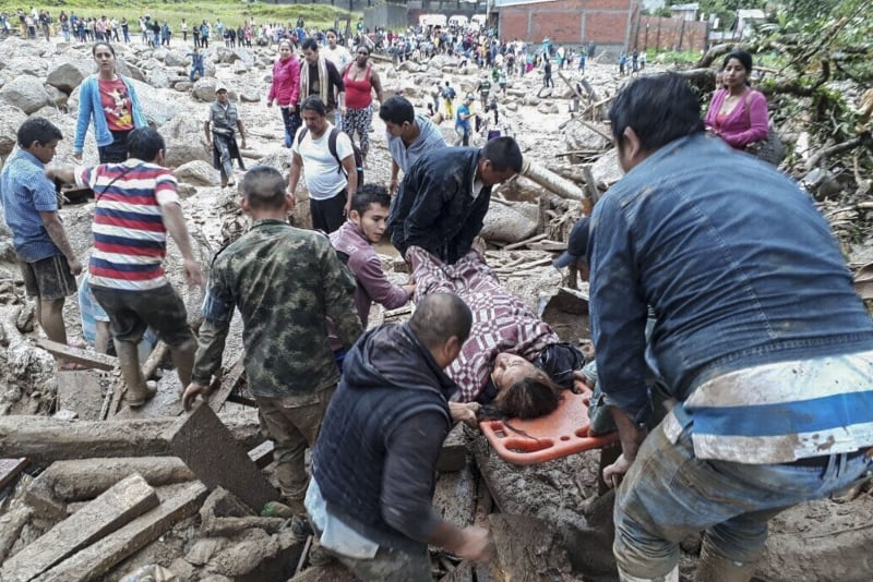 Handout picture released by the Colombian Army press office showing people helping to carry a woman after mudslides following heavy rains, in Mocoa, Putumayo department, on April 1, 2017.
Mudslides in southern Colombia -caused by the rise of the Mocoa River and three tributaries- have claimed at least 16 lives and injured some 65 people following recent torrential rains, the authorities said.   / AFP PHOTO / EJERCITO DE COLOMBIA / HO / RESTRICTED TO EDITORIAL USE - MANDATORY CREDIT AFP PHOTO /  EJERCITO DE COLOMBIA - NO MARKETING - NO ADVERTISING CAMPAIGNS - DISTRIBUTED AS A SERVICE TO CLIENTS