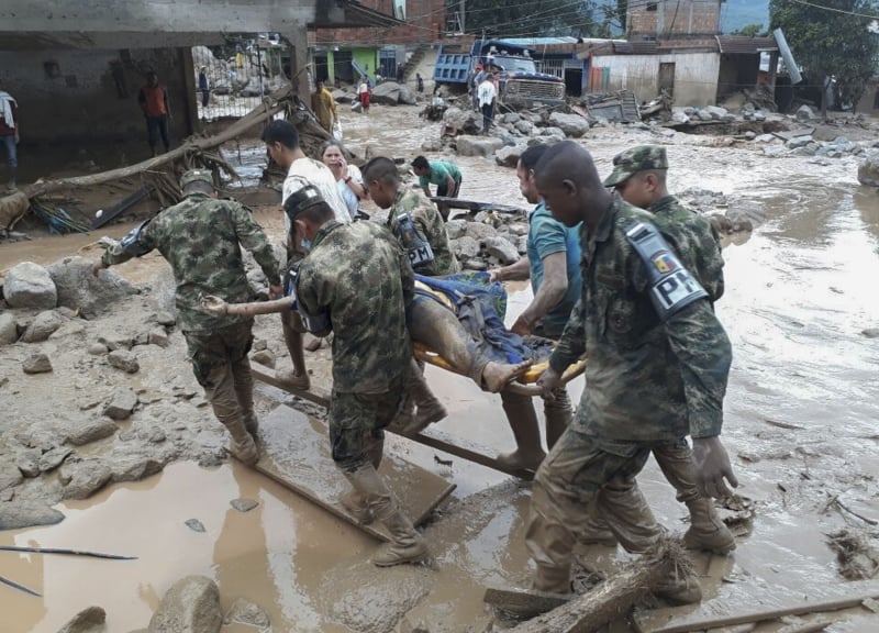 Handout picture released by the Colombian Army press office showing soldiers carrying a corpse following mudslides caused by heavy rains, in Mocoa, Putumayo department, on April 1, 2017.
Mudslides in southern Colombia -caused by the rise of the Mocoa River and three tributaries- have claimed at least 16 lives and injured some 65 people following recent torrential rains, the authorities said.   / AFP PHOTO / EJERCITO DE COLOMBIA / HO / RESTRICTED TO EDITORIAL USE - MANDATORY CREDIT AFP PHOTO /  EJERCITO DE COLOMBIA - NO MARKETING - NO ADVERTISING CAMPAIGNS - DISTRIBUTED AS A SERVICE TO CLIENTS