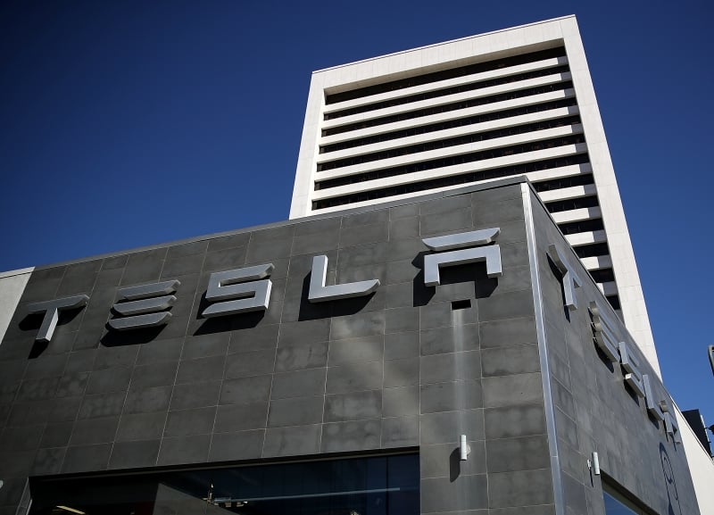 (FILES) This file photo taken on February 22, 2017 shows a sign  posted on the exterior of a Tesla service center o in Los Angeles, California. 
Tesla sold more than 25,000 vehicles in the first quarter, a record that beat analysts' forecasts, the electric carmaker said April 2, 2017. The Palo Alto, California-based carmaker saw deliveries bounce back by 69 percent compared to a rough first quarter in 2016. Tesla produced 25,418 vehicles, a bit above its prior record in the third quarter of 2016.
 / AFP PHOTO / GETTY IMAGES NORTH AMERICA / JUSTIN SULLIVAN