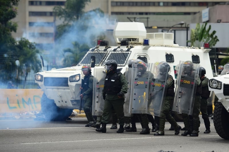 pg3 crise na Venezuela
Riot police clash with opposition activists during a protest against Venezuelan President Nicolas Maduro, in Caracas on May 3, 2017.
Venezuela's angry opposition rallied Wednesday vowing huge street protests against President Nicolas Maduro's plan to rewrite the constitution and accusing him of dodging elections to cling to power despite deadly unrest. / AFP PHOTO / RONALDO SCHEMIDT