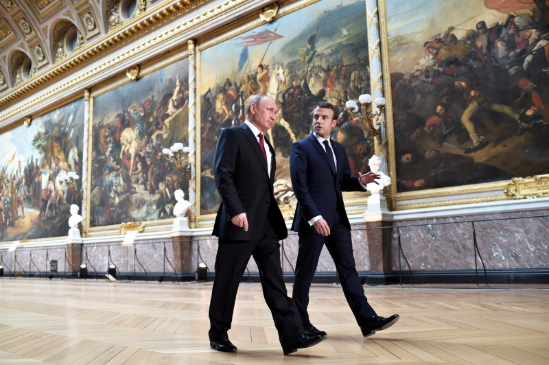 French President Emmanuel Macron (R) speaks to Russian President Vladimir Putin (L) in the Galerie des Batailles (Gallery of Battles) as they arrive for a joint press conference following their meeting at the Versailles Palace, near Paris, on May 29, 2017.
French President Emmanuel Macron hosts Russian counterpart Vladimir Putin in their first meeting since he came to office with differences on Ukraine and Syria clearly visible. Fran�a R�ssia