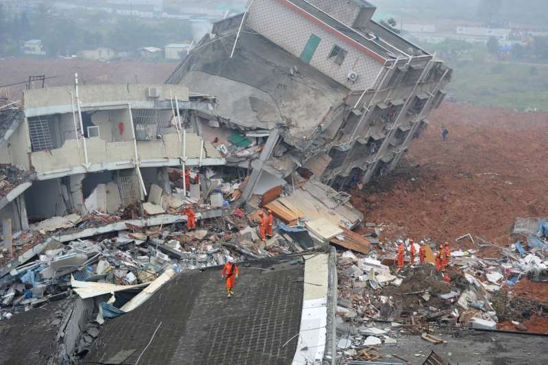int - deslizamento de terra na china   TOPSHOT - Rescuers look for survivors after a landslide hit an industrial park in Shenzhen, south China's Guangdong province on December 20, 2015. A massive landslide at an industrial park in southern China buried 22 buildings and left 22  people missing on December 20, state media reported, as more than 1,500 emergency workers searched the scene. CHINA OUT   AFP PHOTO / AFP / STR
