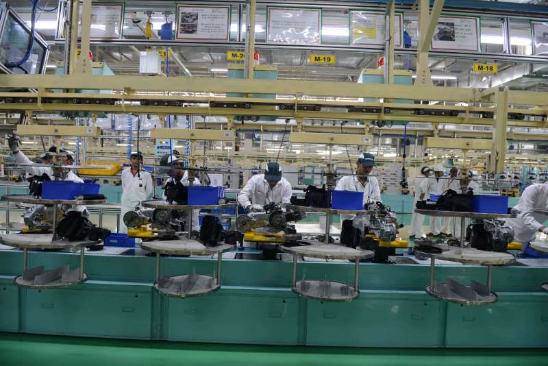 Workers are pictured on the assembly line of Activa scooters at the new plant of Honda Motorcycle and Scooter India Pvt Ltd (HSMI) in Vithalapur, some 80 km from Ahmedabad on February 17, 2016. / AFP / SAM PANTHAKY